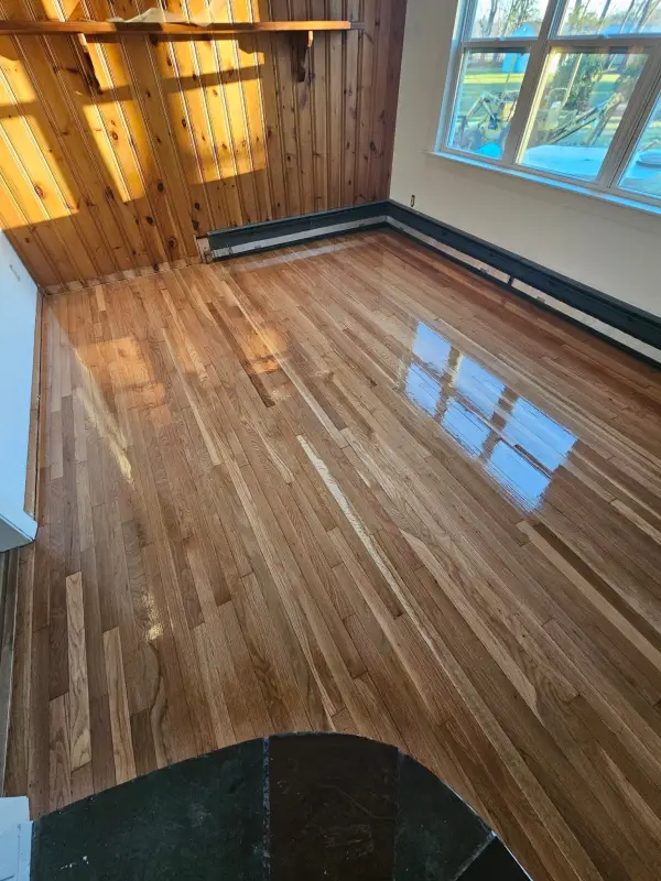 After: the same oak sunroom floor refinished to a bright high-gloss finish