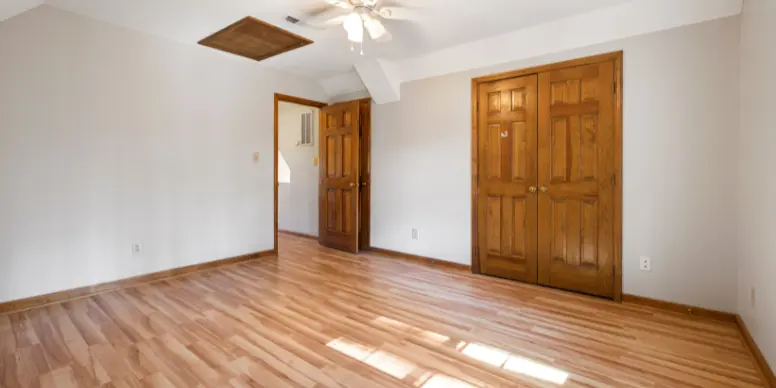 Bright bedroom with a restored honey-colored hardwood floor